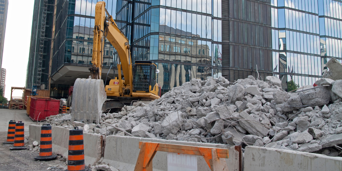 Excavator Moving Piles Of Broken Concrete At A City Demolition Site